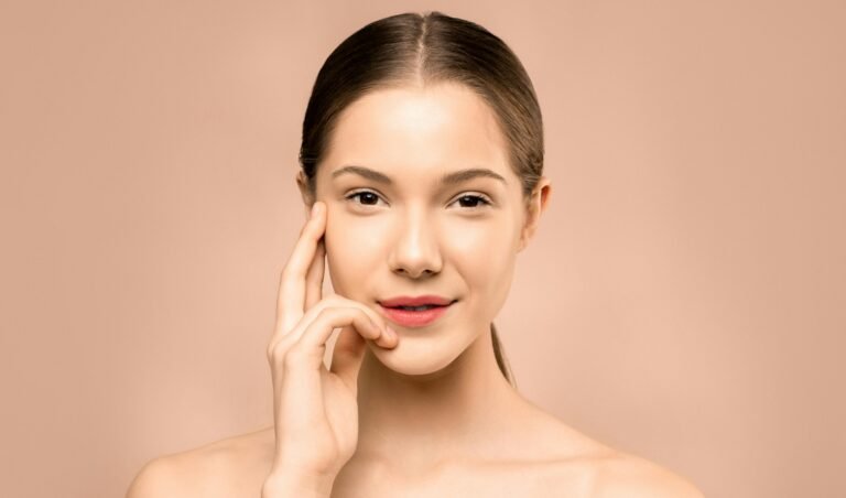 A close-up portrait of a young woman with flawless, radiant skin and a gentle smile, exuding natural beauty.
